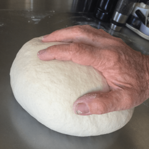 hand resting on ball of dough