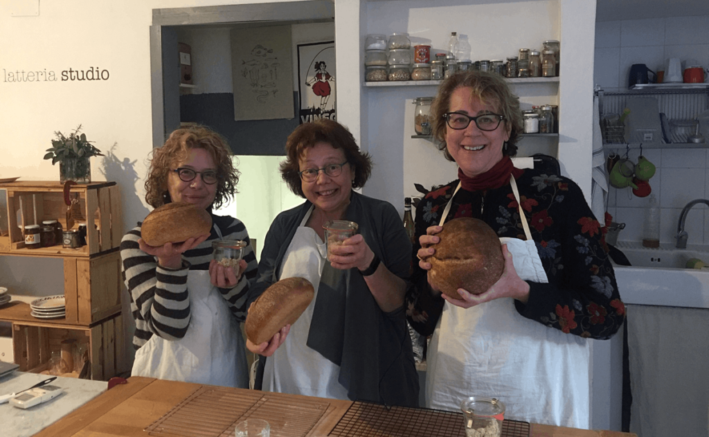 three happy bakers with their bread and sourdough starters