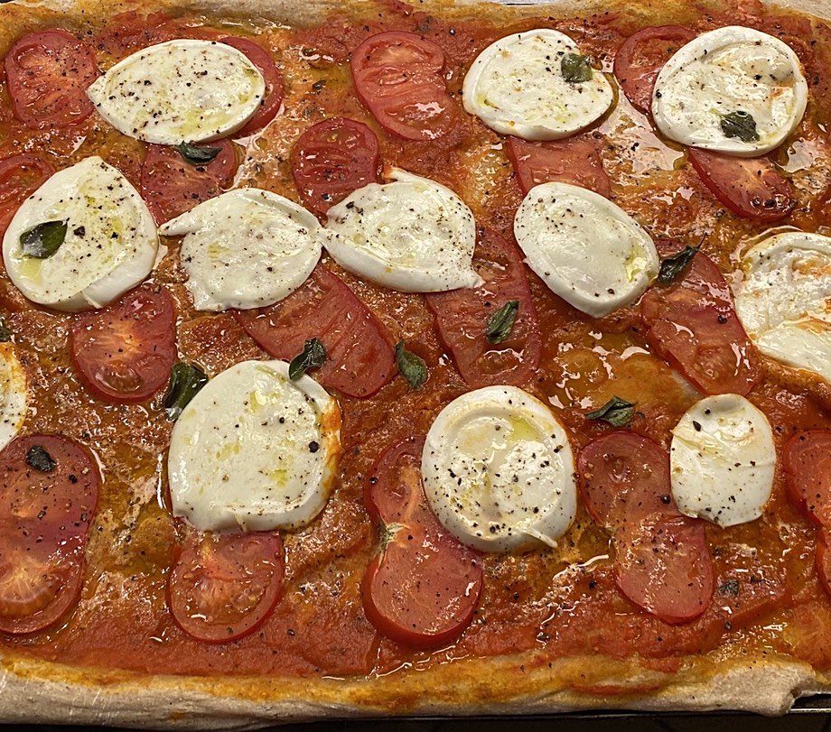 Pizza with mozzarella and fresh tomato on a tomato sauce base