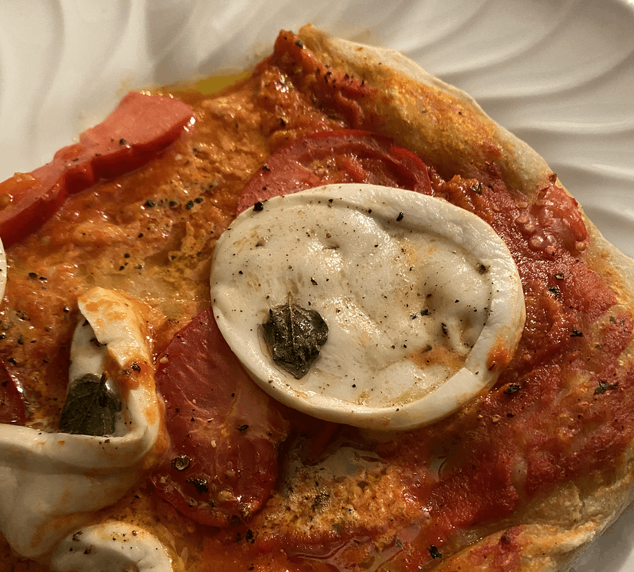 Slice of pizza with mozzarella, fresh tomato and tomato sauce base