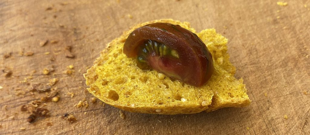 Dark tomato on a slice of golden turmeric bread