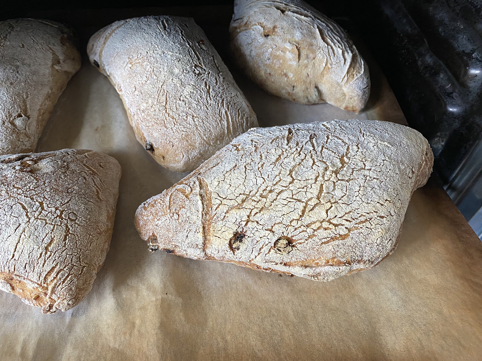 Baked loaves on parchment coming out of the oven