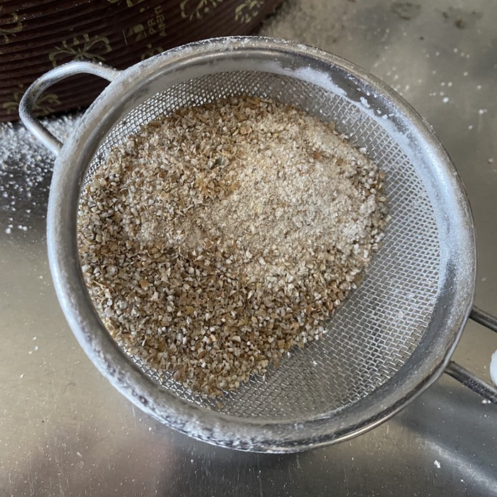 Small sieve containing rye flour and lots of bran particles